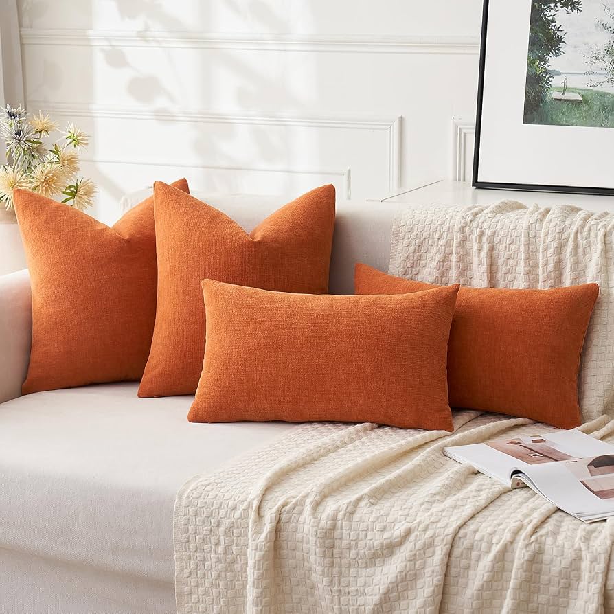Rust and mustard throw pillows on a neutral couch for fall apartment deco